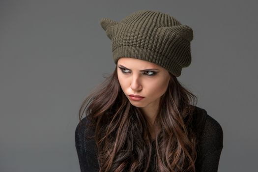 Beautiful sexy young woman in a  funny hat with ears on gray background