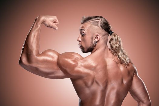 Attractive male body builder on brown background