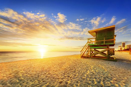 Miami South Beach sunrise with lifeguard tower and coastline with colorful cloud and blue sky. 