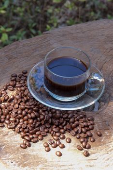 hot coffee with coffee beans on old wood