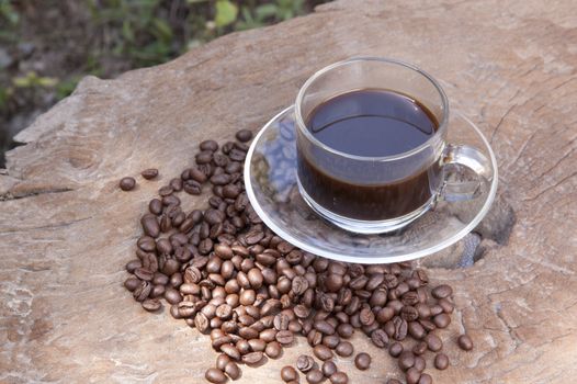 hot coffee with coffee beans on old wood