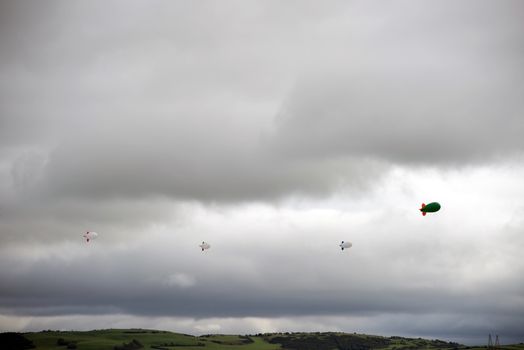 clouds full of air blimps high in the grey sky