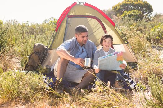 Father and son in their tent on a sunny day