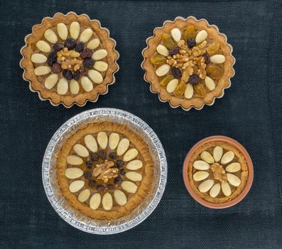 Four round traditional Polish Easter cakes with almonds, raisins and walnuts on the dark background.
