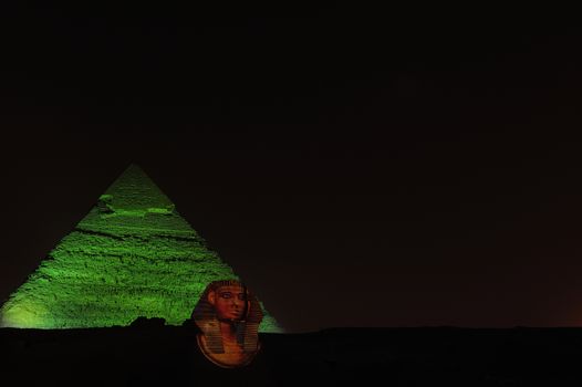 A row of camels transport tourists in front of all of the Giza Pyramids in Cairo, Egypt