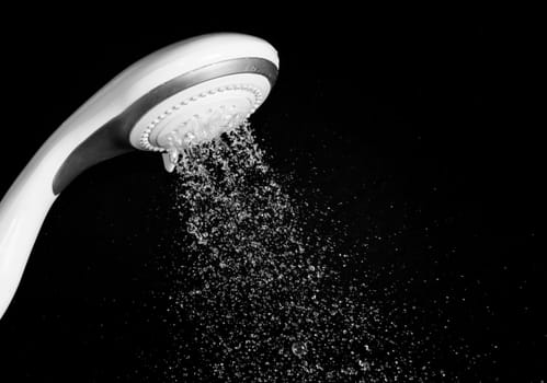 Modern shower head  with running water  isolated on black background