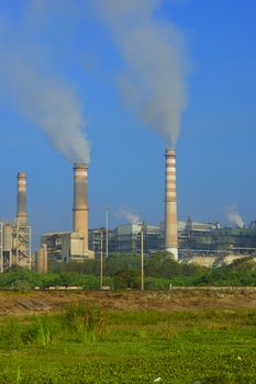 Factory emitting smoke on a bright sunny day