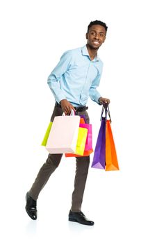 Happy african american man holding shopping bags on white background. Holidays concept