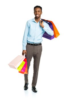 Happy african american man holding shopping bags on white background. Holidays concept