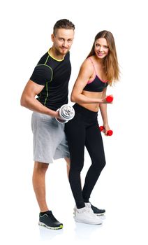 Sport couple - man and woman with dumbbells on the white background