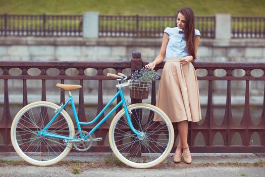 Young beautiful, elegantly dressed woman with bicycle. Beauty, fashion and lifestyle