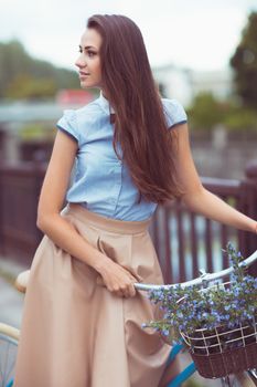 Young beautiful, elegantly dressed woman with bicycle. Beauty, fashion and lifestyle