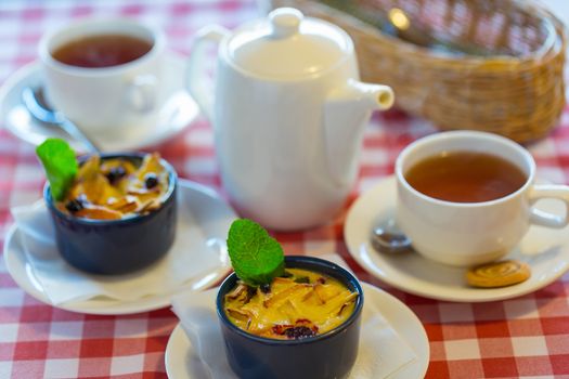 Fruit pudding with mint and tea on a checkered tablecloth