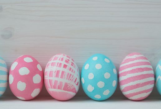 Pink and blue easter eggs on a wooden background