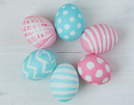 Pink and blue easter eggs on a wooden background