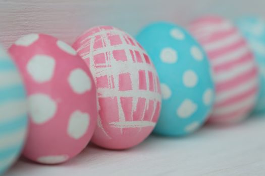 Pink and blue easter eggs on a wooden background