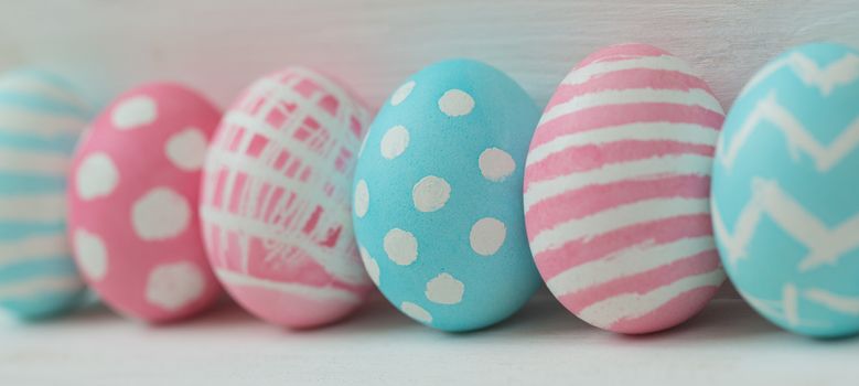Pink and blue easter eggs on a wooden background
