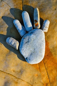 Arm trace of pebbles on the sea boulder