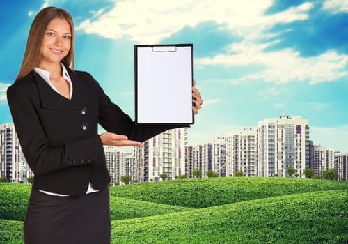 Young woman holding paper holder with nature and city on background. City outdoors
