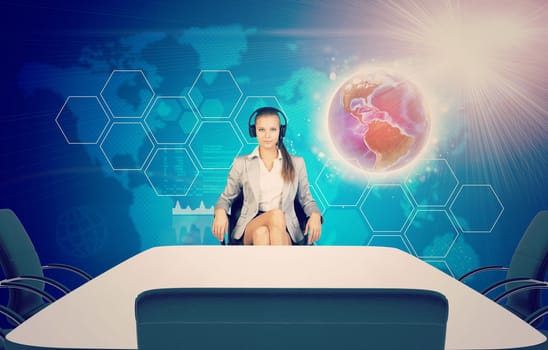 Business lady sitting at table, using headphones and looking at camera on abstract background with world map. Elements of this image furnished by NASA