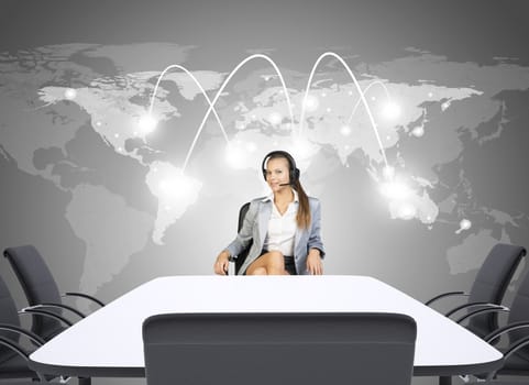 Businesswoman sitting in chair with earphones and looking at camera. World Map and Communication background