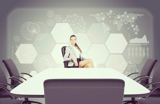 Colorless picture of Business lady sitting at table and looking at camera. Abstract background with graphical charts and world map