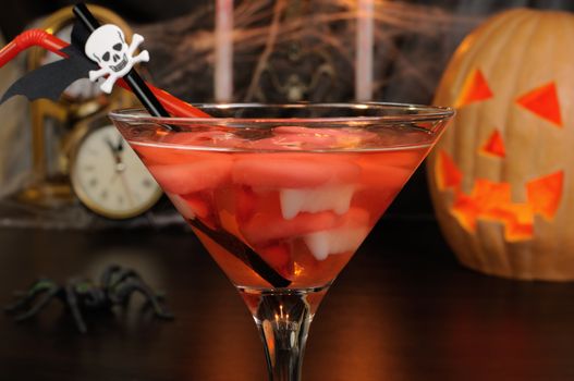 Cocktail glass filled with vampire teeth on the table for Halloween