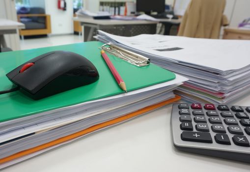 Pile of document and stationery supplies on desk in office.                                