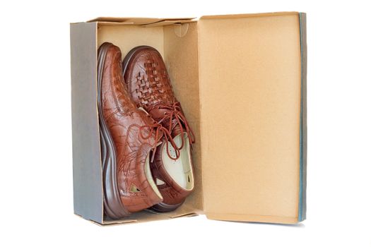 A pair of comfortable mens shoes dark color in a cardboard box. Presented on a white background.