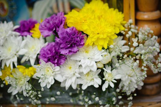 Bouquet of White yellow and purple flowers in church.