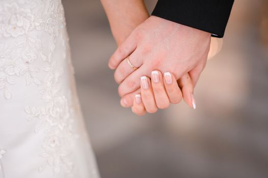 Bride and groom holding hands outdoors