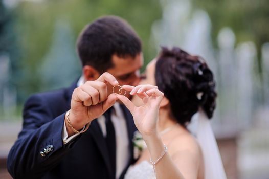 bride and groom holding the ring in the foreground