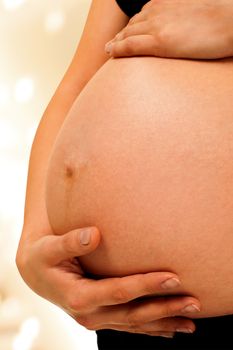 Pregnant woman is holding her abdomen on light background, isolated with work path.