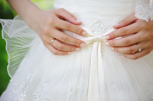 Bride holding a bow on a wedding dress