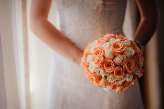 bride holding a wedding bouquet with white and pink roses