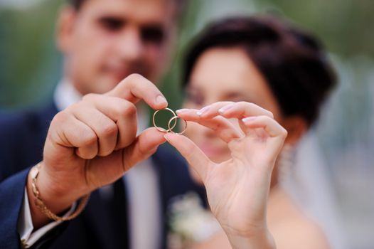 bride and groom holding hands in a ring