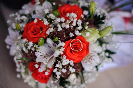 gold wedding rings on a bouquet of roses