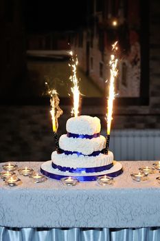 beautiful wedding cake on a table with candles