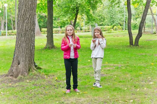 Photo of two eating girls in summer