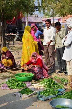 Jodhpur, India - January 2, 2015: Indian people shopping at typical vegetable street market in India on January 2, 2015 in Jodhpur, India. Food hawkers in India are generally unaware of standards of hygiene and cleanliness.