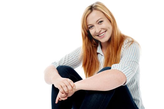 Charming woman sitting on floor posing to camera