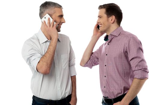 Two young friends happily talking on mobile phone