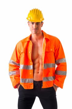 Handsome young construction worker with orange suit open on naked torso, smiling, isolated on white