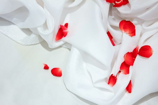 Rose petals on white fabric with background