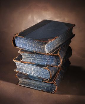 stack of old books on a painted canvas backdrop