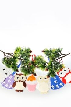 Handmade Christmas decorations made of felt hanging on a rope. Felt Santa boots, felt Christmas tree and felt mittens. owl, a bell and a Cake