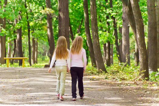 Photo of cute two girls walking in park