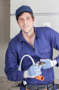 Happy man repairing a pipe