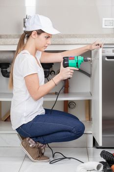Woman plumbing working with drill