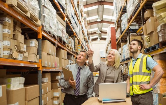 Cheerful warehouse team working together in a large warehouse